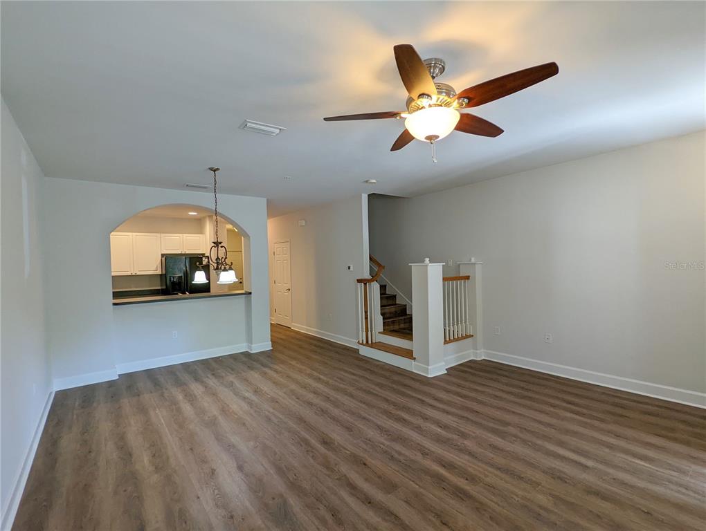 7782 Southwest 64th Lane, Unit 1002 Gainesville, FL 32608 - Photo 4 of 42 a view of a livingroom with a ceiling fan and wooden floor