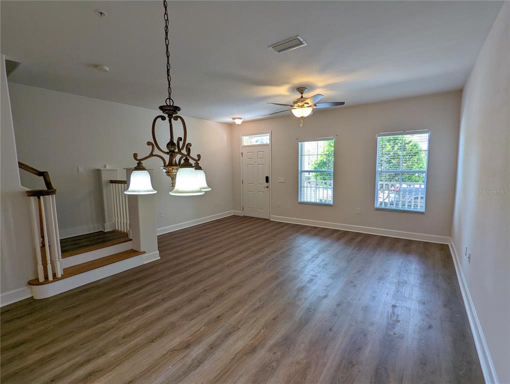 7782 Southwest 64th Lane, Unit 1002 Gainesville, FL 32608 - Photo 5 of 42 a view of an empty room with wooden floor and a ceiling fan