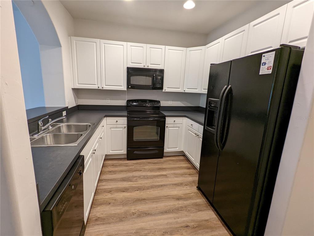 7782 Southwest 64th Lane, Unit 1002 Gainesville, FL 32608 - Photo 7 of 42 a kitchen with granite countertop a refrigerator stove and sink
