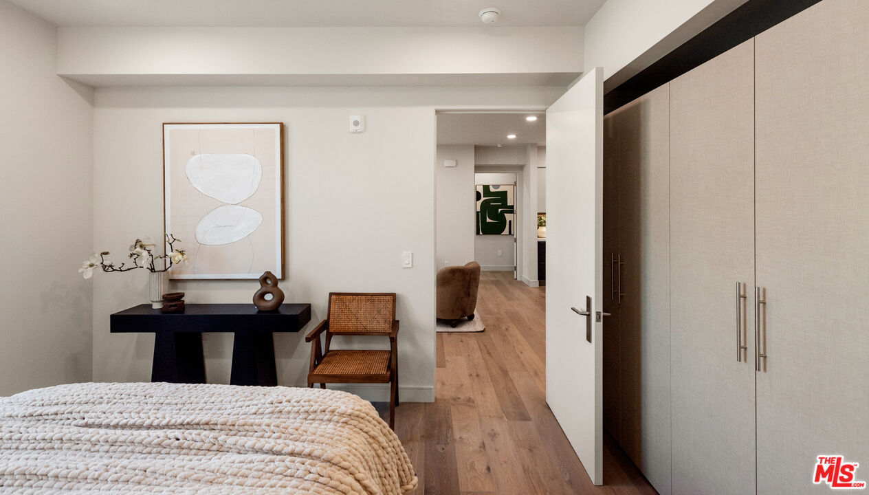 505 South Barrington Avenue, Unit 303 Los Angeles, CA 90049 - Photo 11 of 41 a bedroom with a bed and wooden floor