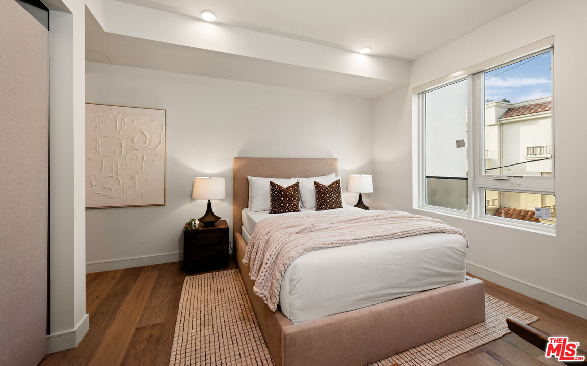 505 South Barrington Avenue, Unit 303 Los Angeles, CA 90049 - Photo 12 of 41 a bedroom with a bed and wooden floor