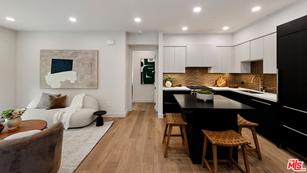 505 South Barrington Avenue, Unit 303 Los Angeles, CA 90049 - Photo 3 of 41 a kitchen with stainless steel appliances kitchen island granite countertop a sink and cabinets