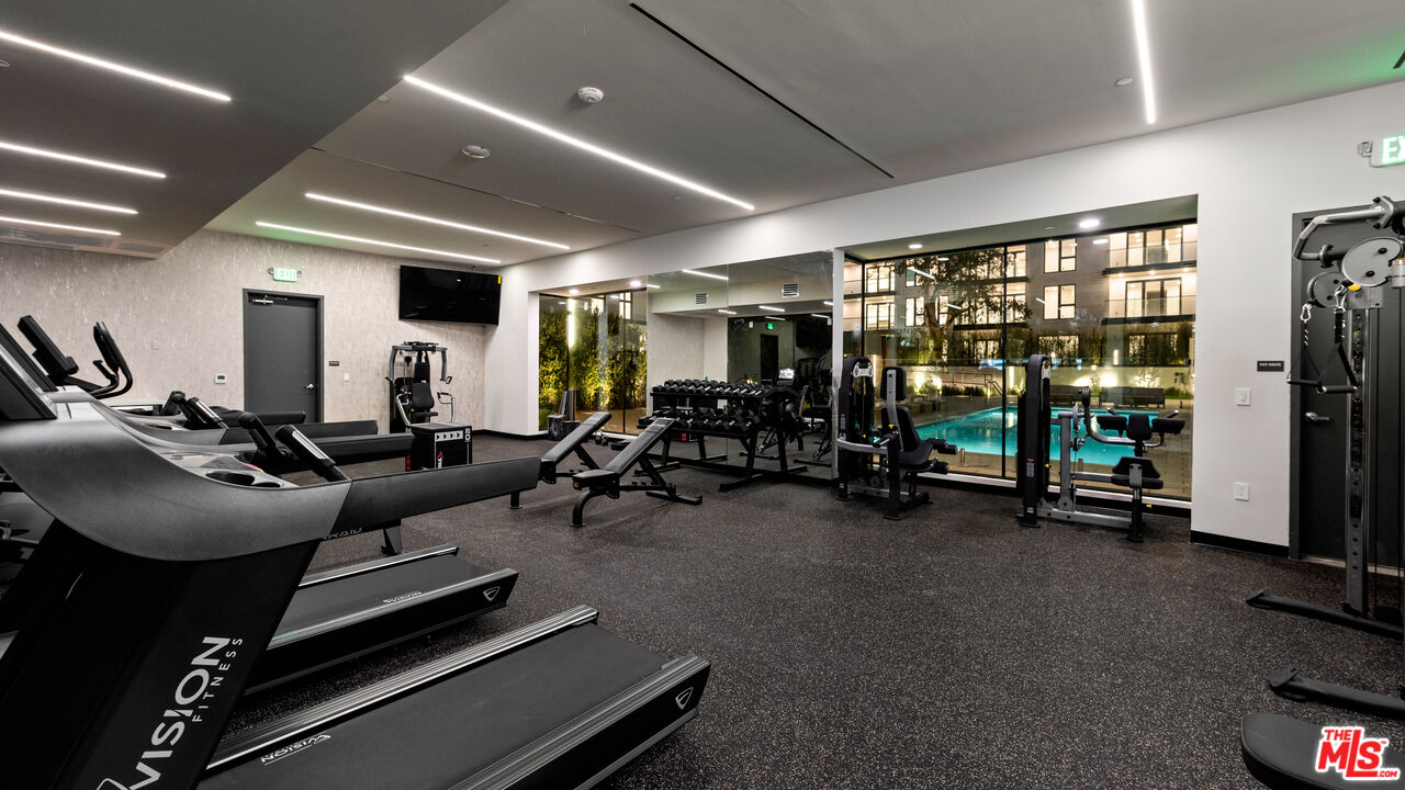 505 South Barrington Avenue, Unit 303 Los Angeles, CA 90049 - Photo 35 of 41 a room with gym equipment and a large window