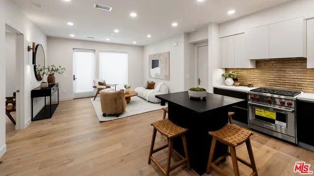 a living room with furniture a flat screen tv and a table