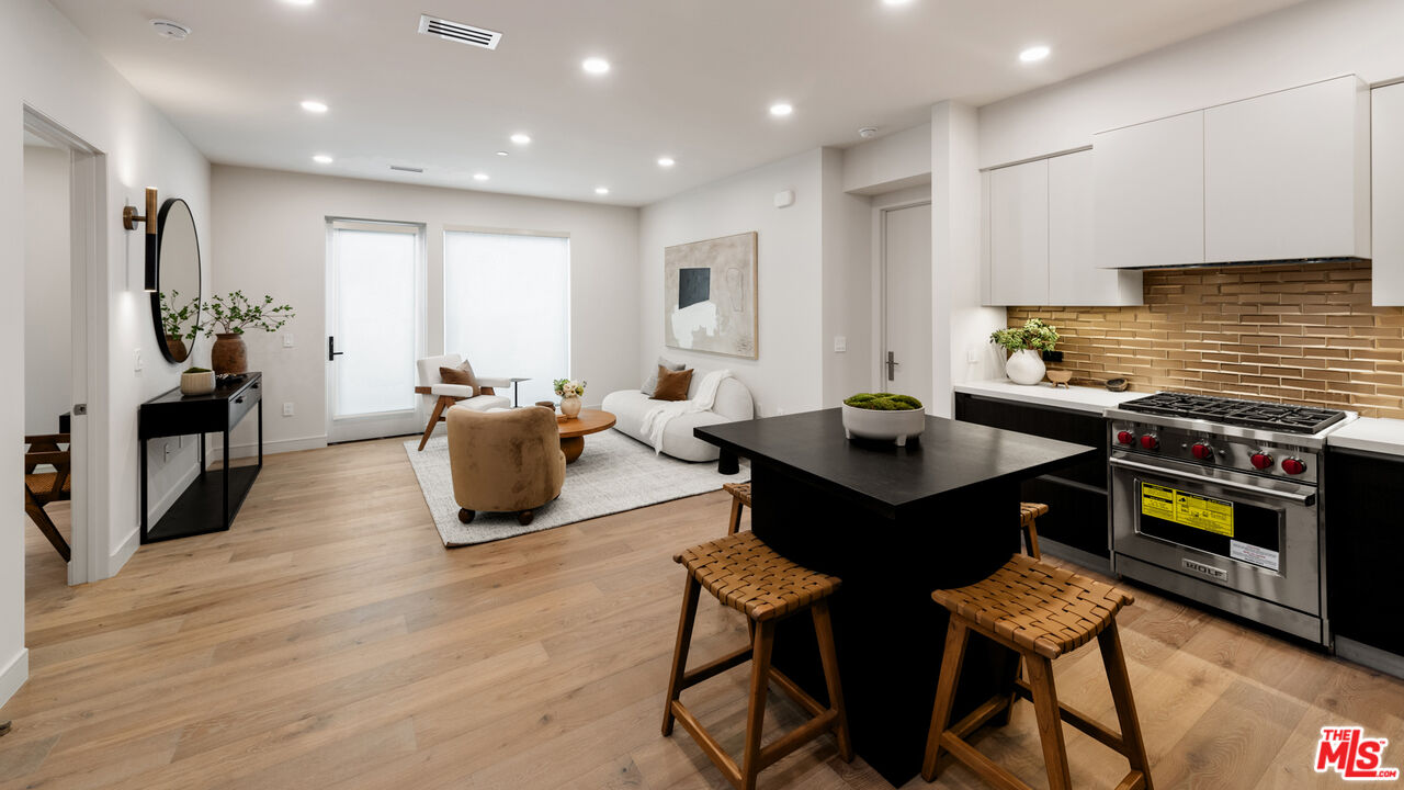 505 South Barrington Avenue, Unit 303 Los Angeles, CA 90049 - Photo 7 of 41 a living room with furniture a flat screen tv and a table