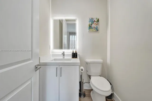 a bathroom with a toilet a sink and mirror