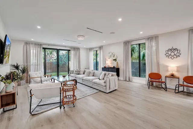 a living room with furniture and large windows