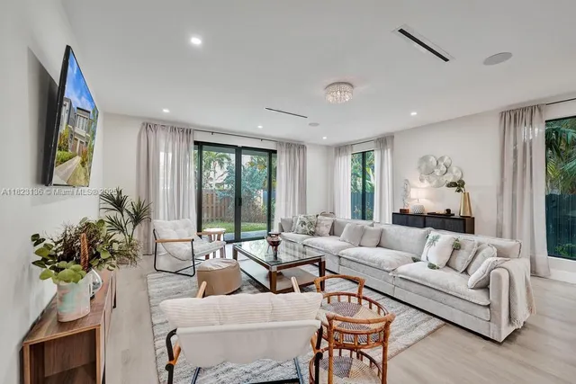 a living room with furniture flower pot and a large window