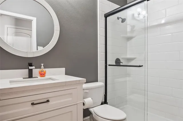 a bathroom with a sink a toilet and a mirror