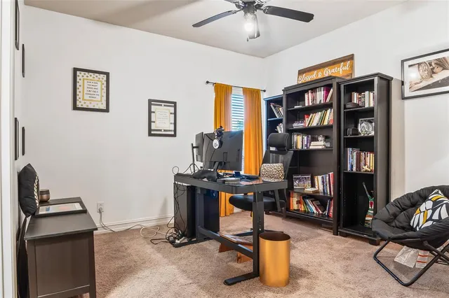 a view of a workspace with furniture and a bookshelf