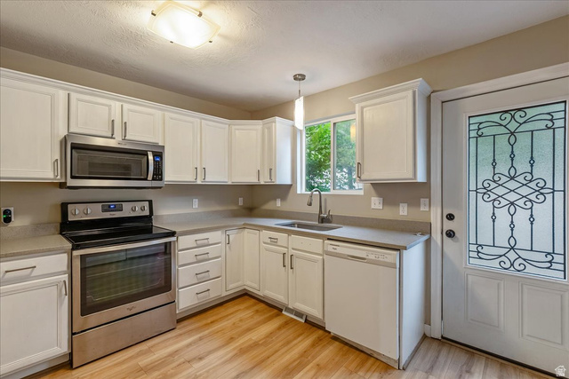 38 South 1000th Street East Payson, UT 84651 - Photo 9 of 19 Bright kitchen featuring white cabinetry, wood-finish flooring, and a stainless steel oven/range and microwave