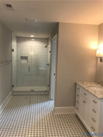 a bathroom with a sink a toilet a mirror and shower