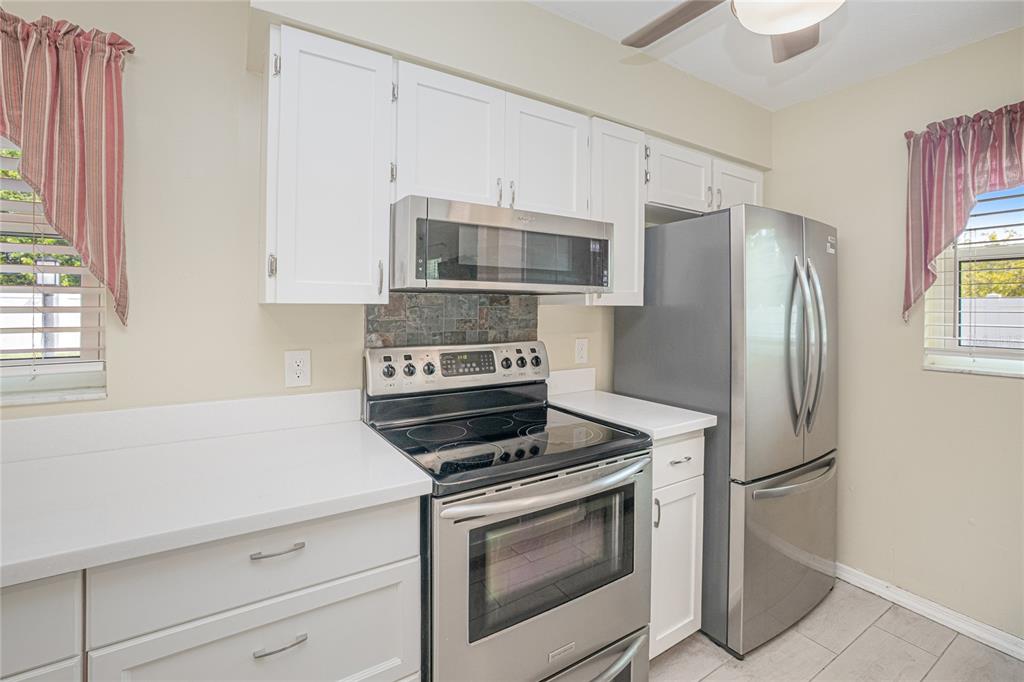 24540 Harbor View Road, Unit D3 Punta Gorda, FL 33980 - Photo 11 of 33 a kitchen with cabinets stainless steel appliances and a window