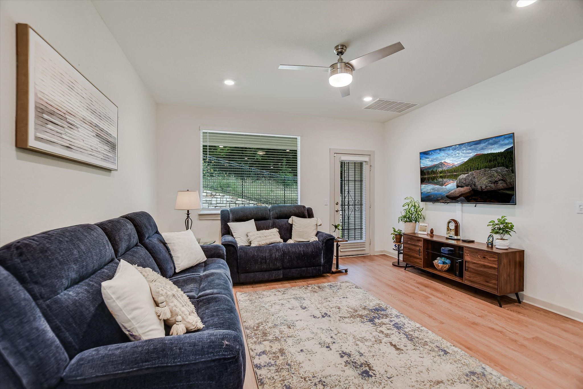 105 Merrick Road Georgetown, TX 78628 - Photo 6 of 23 A comfortable living space boasts durable laminate flooring, recessed lighting, and a private outdoor exit.