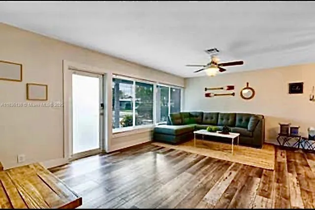 a living room with furniture and floor to ceiling window