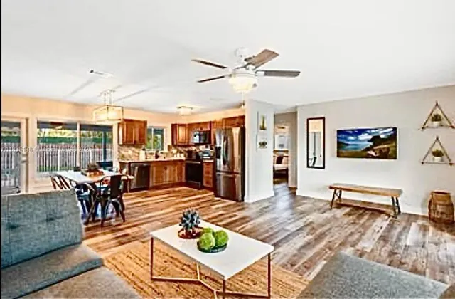 a living room with furniture kitchen view and large windows