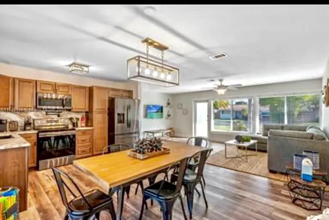a view of a dining room with furniture large windows and wooden floor