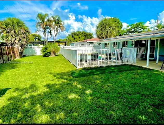 a view of house with a big yard and potted plants