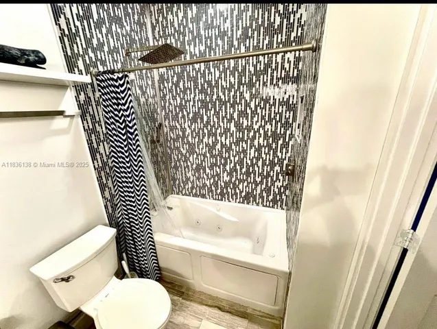 a bathroom with a toilet and a shower curtain
