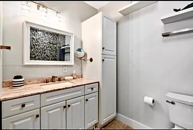 a bathroom with a sink a toilet a mirror and shower