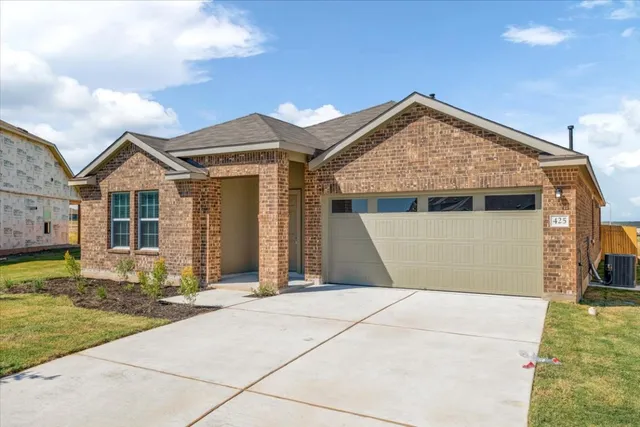 a view of a house with a small yard and potted plants