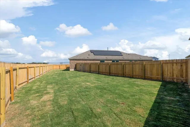 a view of backyard of house with green space