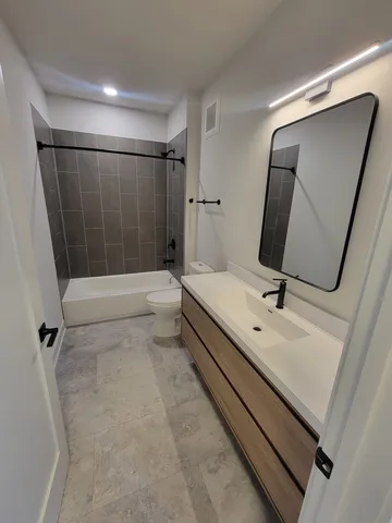 a bathroom with a sink a toilet a mirror and shower