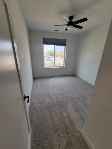 a view of a livingroom with a ceiling fan and window