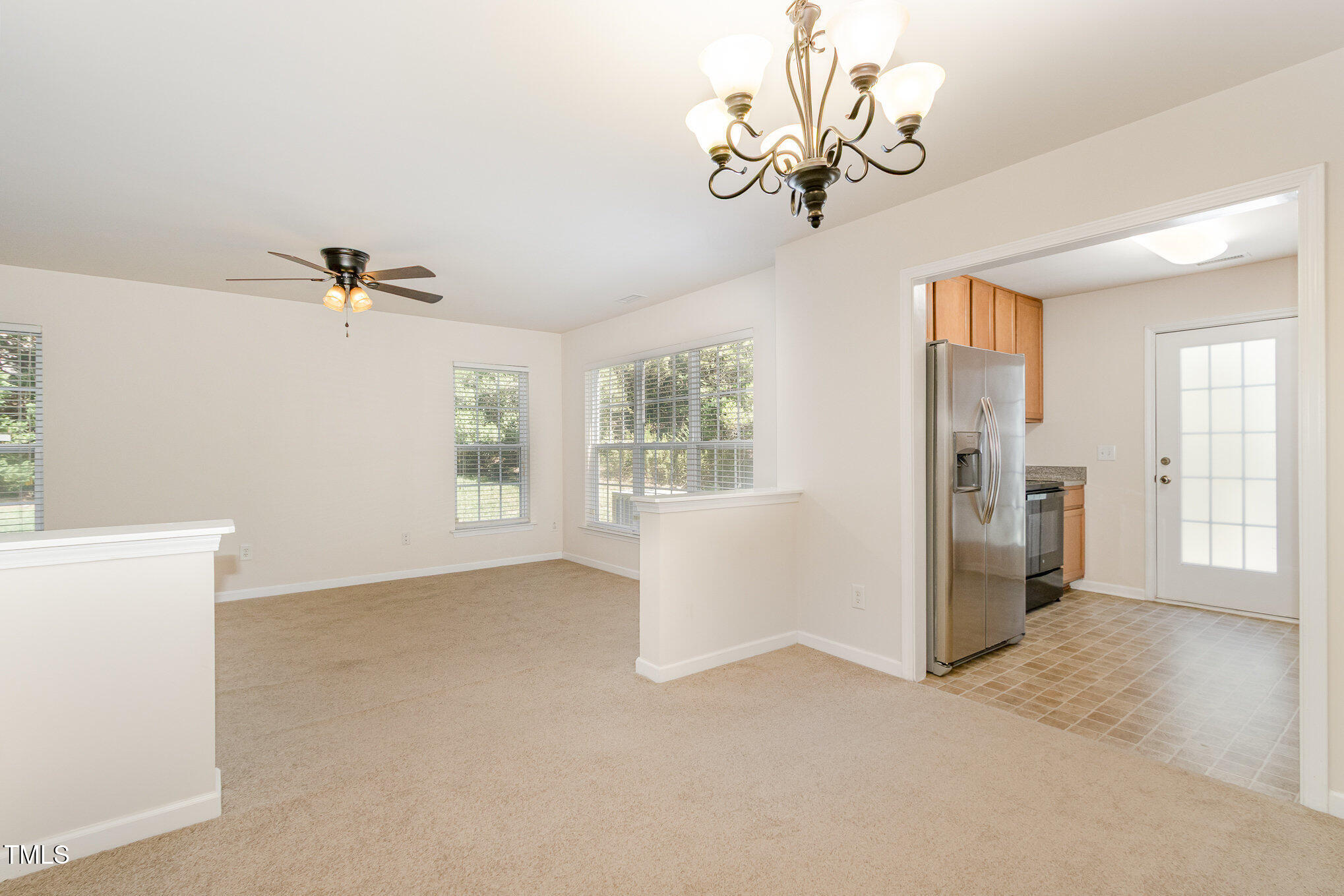 2126 Kedvale Avenue Raleigh, NC 27617 - Photo 7 of 18 a view of a big room with windows and chandelier fan