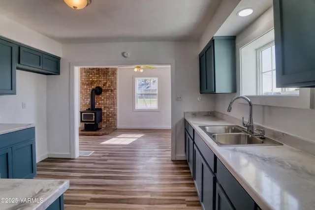 a kitchen with granite countertop a sink stove and cabinets