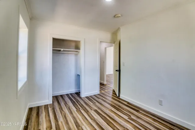 a view of a room with wooden floor and a bathroom