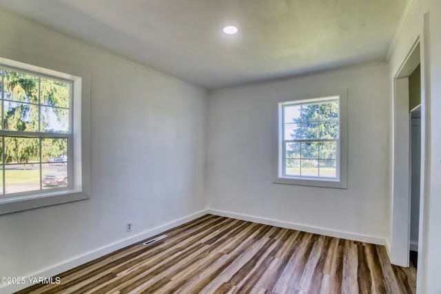 a view of a room with wooden floor and windows