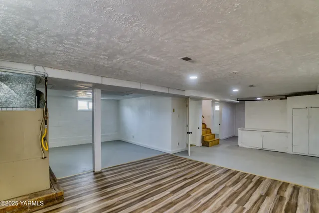 a view of a room with wooden floor and furniture