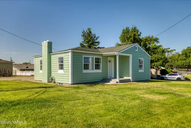 a front view of a house with a garden