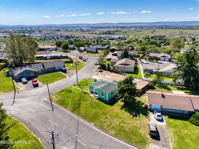 an aerial view of residential houses with outdoor space and trees all around