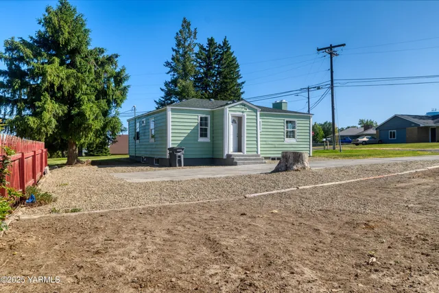 a view of a house with a yard and potted plants