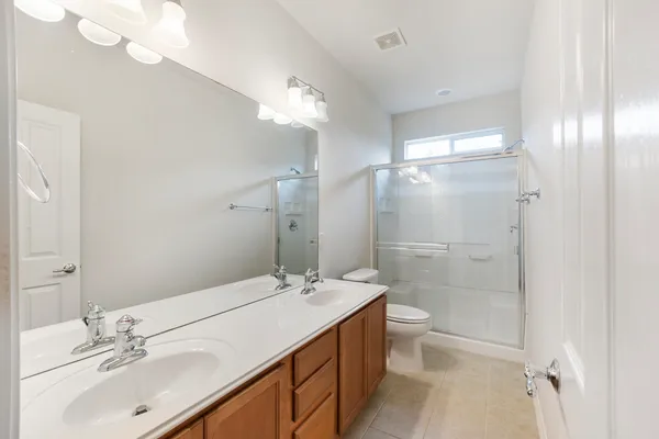 a bathroom with a double vanity sink mirror and toilet
