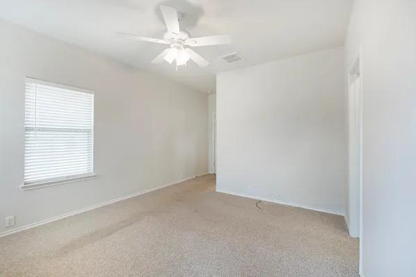 an empty room with windows and fan