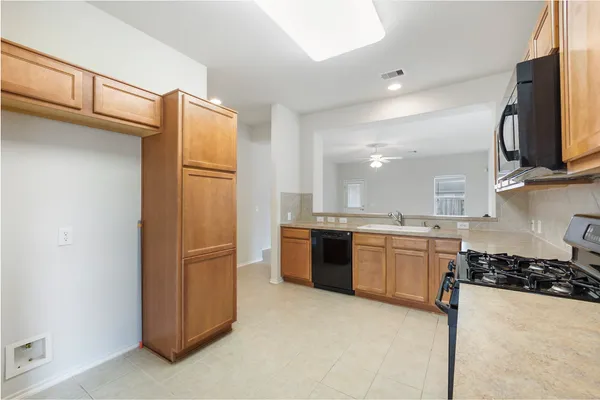 a kitchen with stainless steel appliances granite countertop a refrigerator and a stove top oven