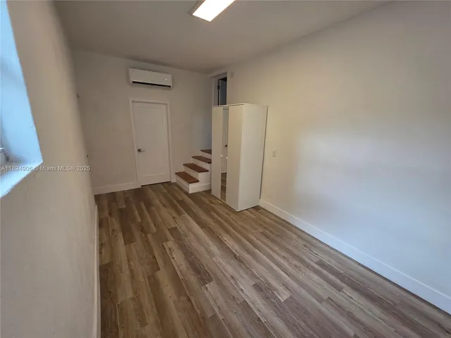 a view of a room with wooden floor and white walls