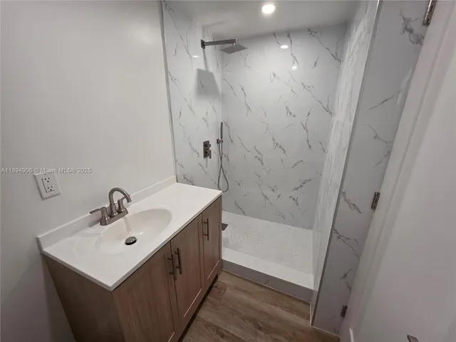 a bathroom with a sink a shower and a mirror