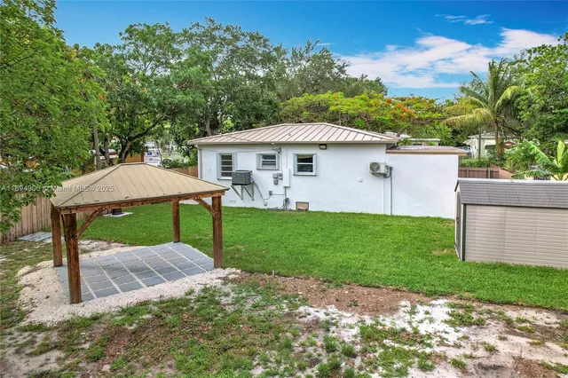 a view of a patio with a table and chairs under an umbrella