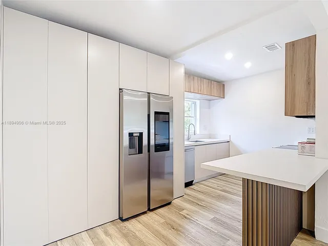 a kitchen with stainless steel appliances a refrigerator and a stove top oven