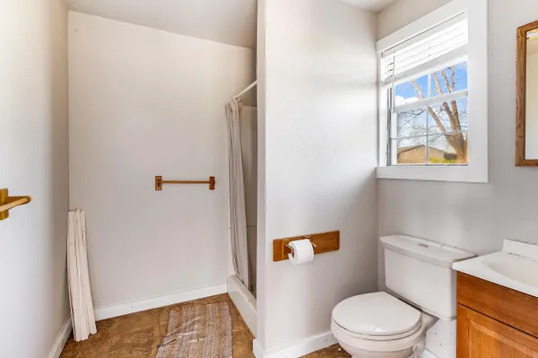 a white toilet sitting next to a bathroom sink and a window