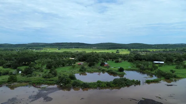 an aerial view of green landscape with trees houses and mountain view