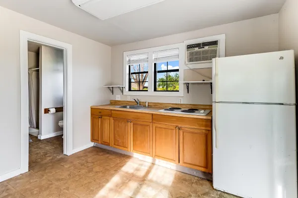 a kitchen with stainless steel appliances granite countertop a refrigerator a stove a sink and a more cabinets