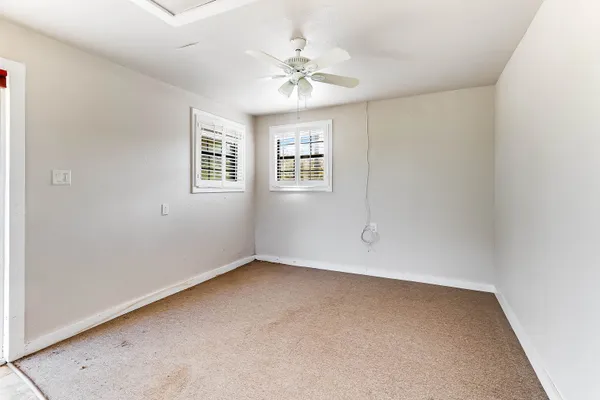 an empty room with a window and a ceiling fan