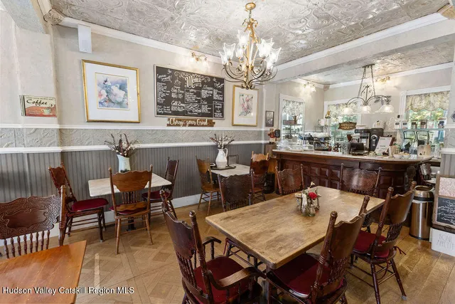 a view of a dining room with furniture a chandelier and wooden floor