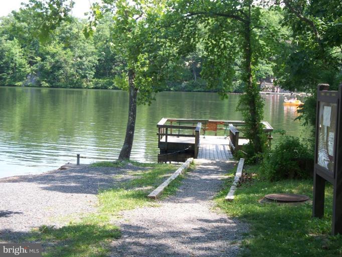 39 Montevideo Road Berkeley Springs, WV 25411 - Photo 4 of 8 a wooden bench sitting next to a lake