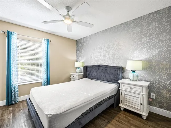 a bedroom with a bed a chandelier and a window